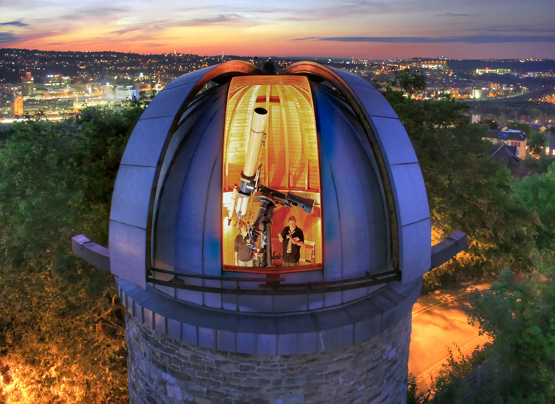Foto von der Sternwarte Uhlandshöhe, mit geöffnetem Dach und Einblick in die Sternwarte.